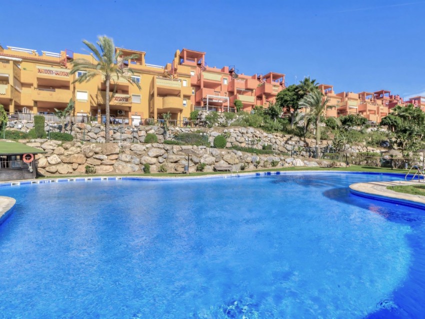 Private Terrasse in der Reserva de Marbella Zweizimmerwohnung mit Terrasse mit Blick auf gepflegte Gärten und Pools.